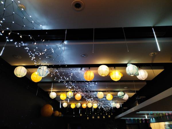 コスモプラネタリウム渋谷のロビーの天井に吊るされた色とりどりの提灯とイルミネーションライト