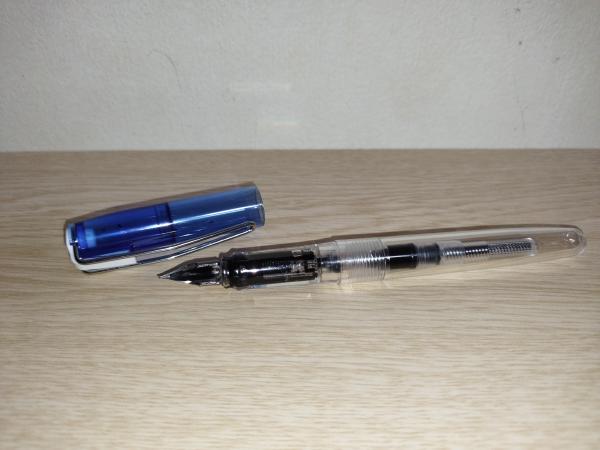ブラックのインクを吸入したあとのコンバーター式万年筆　スタンダードです。青い透明なキャップが外されています。万年筆は首軸も含め透明なので、インクが充填されているのがひと目でわかります