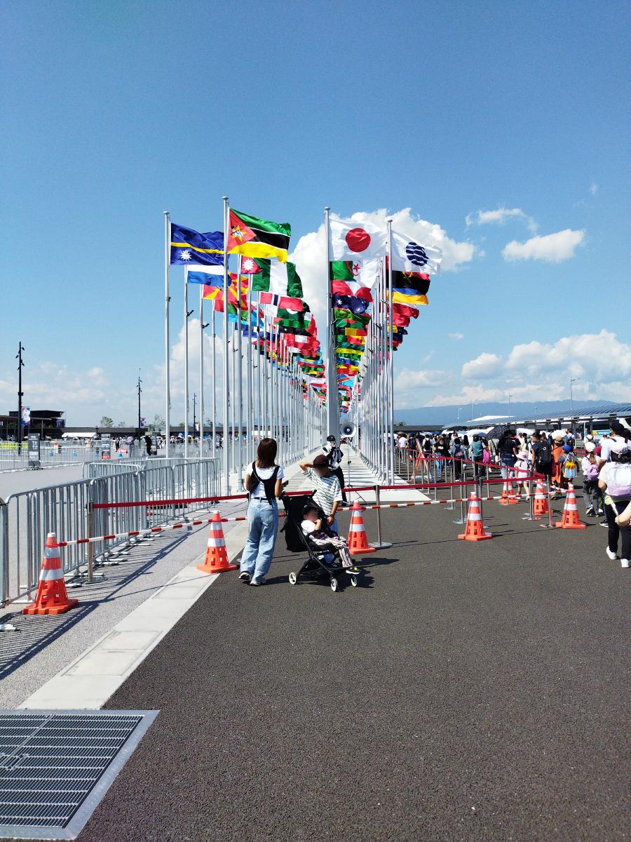 青空の下でたなびく万博参加国の国旗。