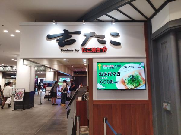 「Produce by たこ焼きブ! 吉たこ」の店の入り口と、ネギがたくさんのったたこ焼きのメニュー画面。