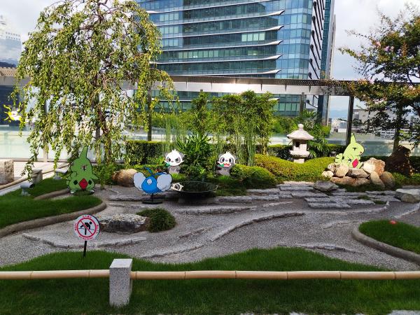 建物の屋外広場にある日本庭園風のスペースです。砂利と芝生で構成された枯山水の中に、チルタリスやヨーギラス、ヤンチャムのパネルが飾られています。