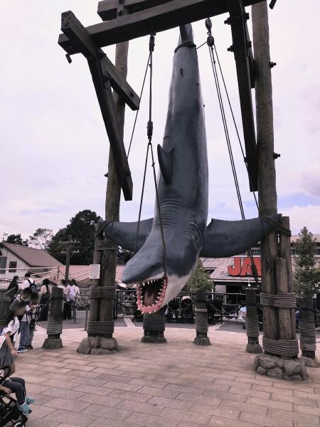 映画『ジョーズ』エリアで、木製の梁から逆さに吊るされた巨大なサメの模型。