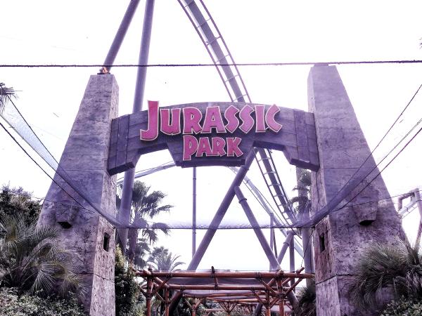 巨大な石造りの門に、赤色の文字で「JURASSIC PARK」と書かれたエリア入り口。