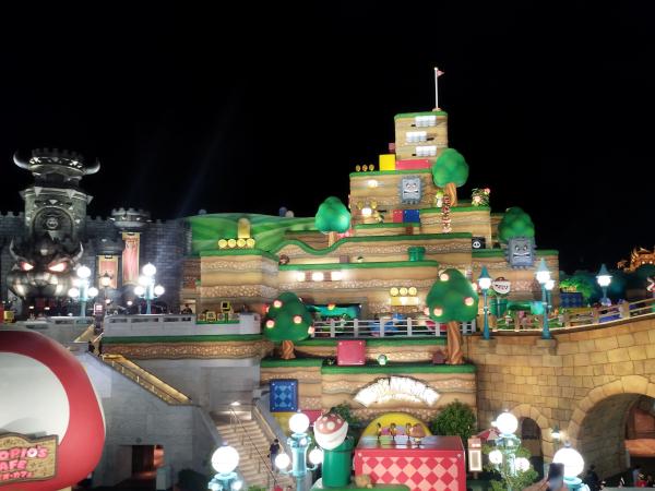 夜のスーパー・ニンテンドー・ワールド。パックンフラワーやブロックなどが見える楽しい雰囲気。